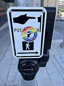 Rainbow-colored Starbucks Workers United sticker on a crosswalk sign in Seattle, Washington, in June 2023 Seattle - WA - June 2023 - 53.jpg