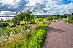 Vy mot väster. Till vänster sjön Östra Kyrksundet, till höger byn. 1 augusti 2023.