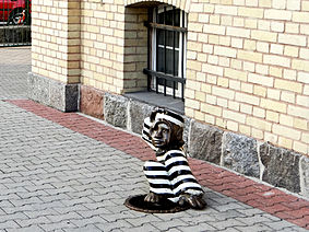 Figurka uciekającego pofajdoka przed budynkiem sądu rejonowego w Szczytnie.