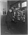 Thomas Alva Edison, 1847-1931, punching time clock on his 74th birthday anniversary, February 11, 1921, standing, rear view LCCN2005687286.jpg