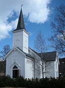 Foto einer kleineren weißen Holzkirche mit schwarzem Dach