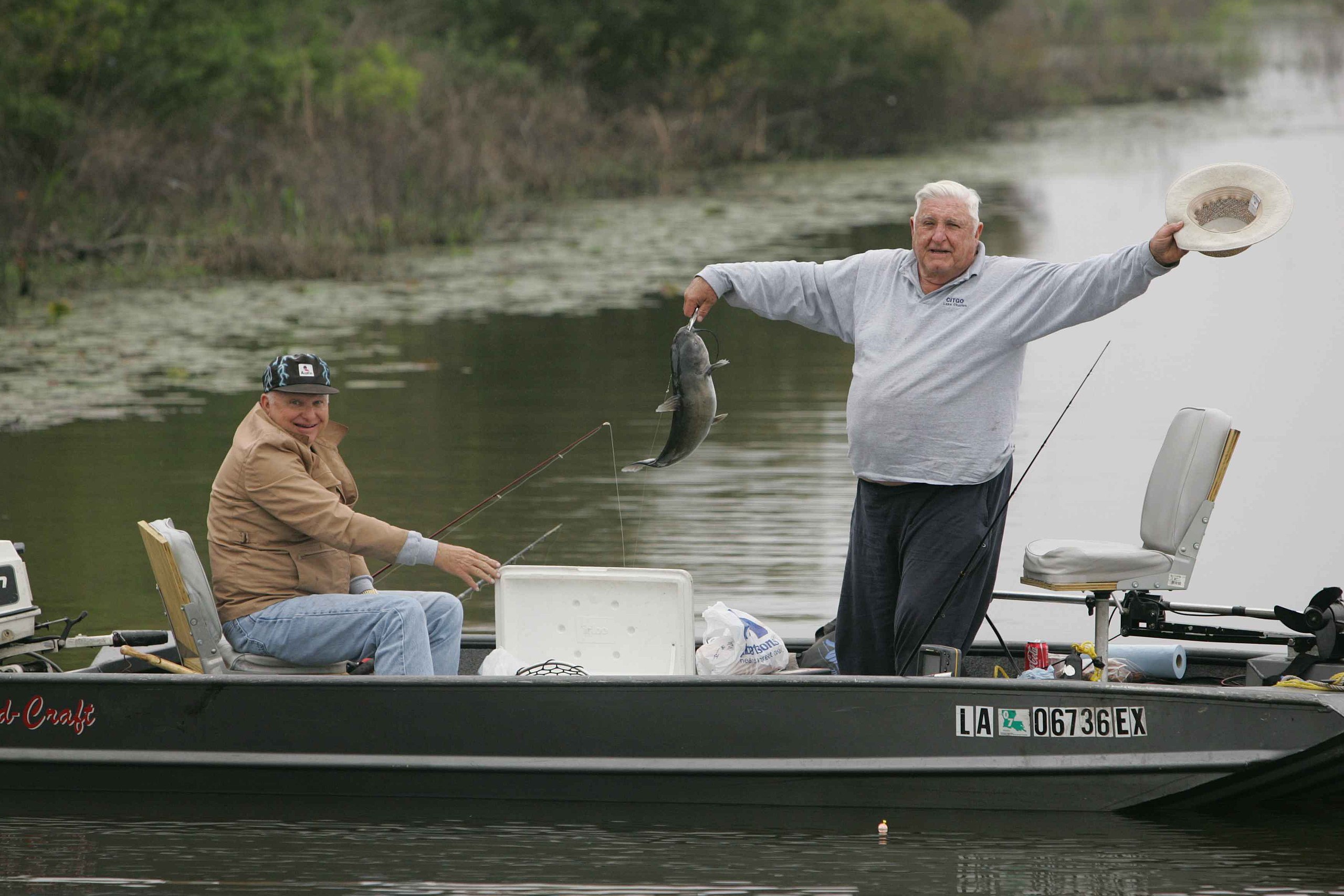 File:Two older men enjoying fishing from boat one man is standing and  raising hat while showing the fish he just caught.jpg - Wikimedia Commons