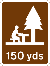 In UK road signs, shorter distances (such as picnic area 150 yards ahead) are given in yards, with longer distances given in miles UK traffic sign 2305.svg