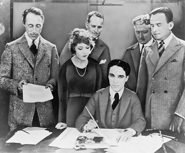 D. W. Griffith, Mary Pickford, Charlie Chaplin (seated) and Fairbanks at the signing of the contract establishing United Artists in 1919