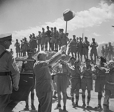 Winston Churchill salutes allied troops in the Roman amphitheatre at Carthage, during a visit to troops near Tunis, June 1943