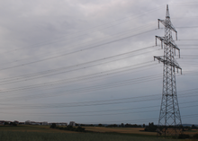 A powerline tower west of Sindelfingen-Darmsheim with two garland-like communication cables, one on the ground conductor and one on an auxiliary rope below it. Anlage318 Mast64 29062023.png