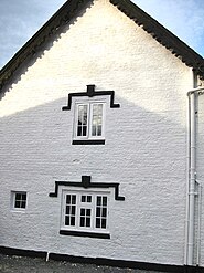 End brick gable of stone wing with Tudoresque window detailing