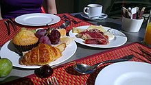 A continental breakfast of muffins, croissants and bread, fruit, slices of cheese and meat Continental Breakfast.jpg