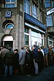 DF-ST-91-01443 East German refugees line up at a Deutsche Bank to receive an allotment of 100 Deutsche Mark, November 1989.jpeg