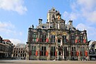 Photographie en couleurs de la façade d'un bâtiment public et de son environnement urbain.