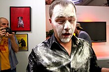 A person whose face and clothes have been hit by a flour bomb Flour bombed.jpg