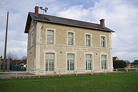 Passagiersgebouw aan de baanzijde met gazon op de voorgrond, in plaats van de ontbrekende sporen.