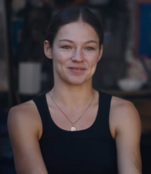 Kateryna Pavlenko smiling at the camera. She is wearing a black sleeveless shirt and a necklace.