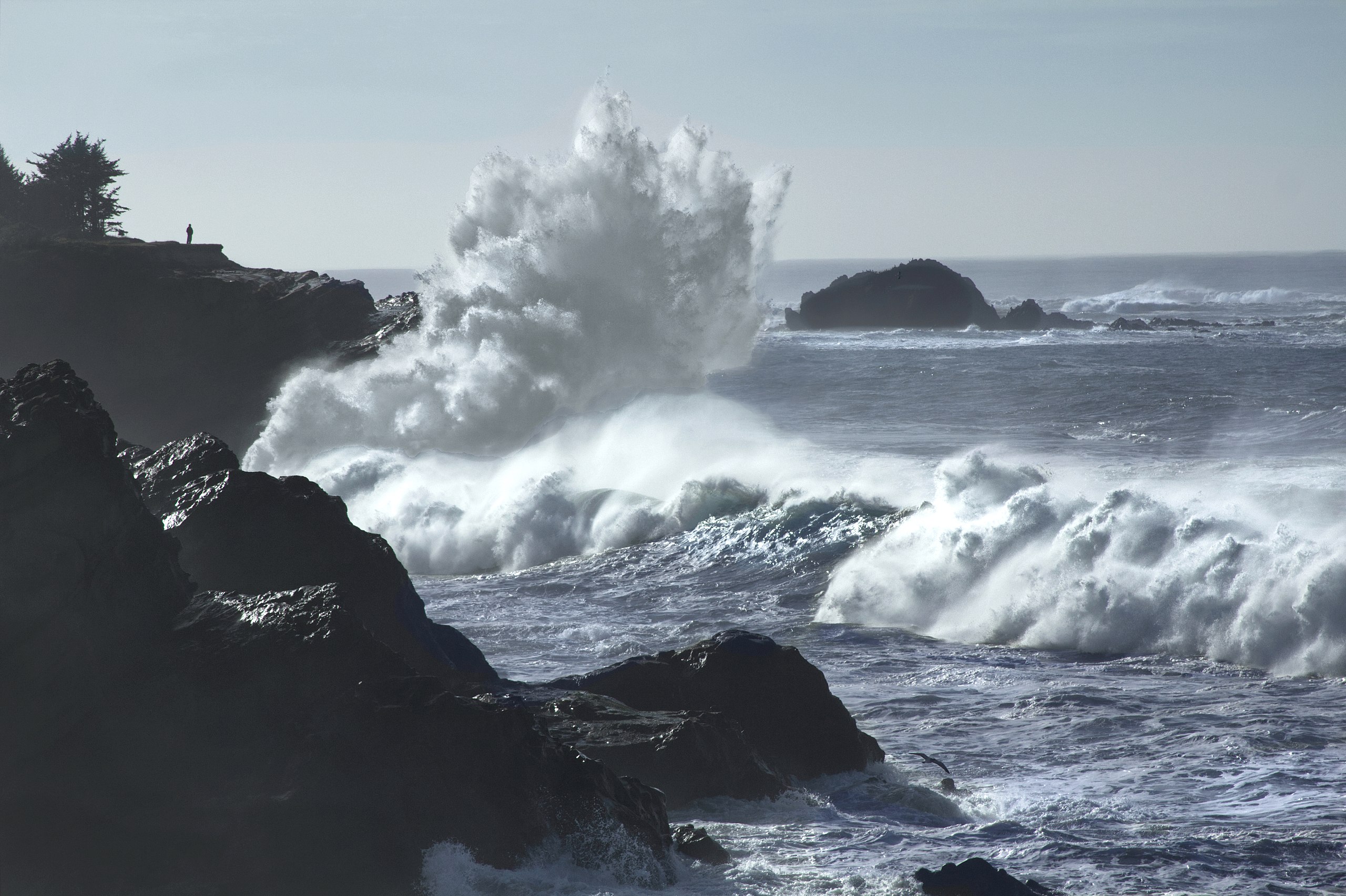 sea with big waves crashing to shore and rocks