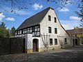 Residential house, side building, barn, courtyard paving and front garden of a three-sided courtyard