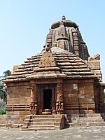 The front portion of the jagamohana depicts nagins and guarding deities in the doorjambs, with vimana in the background. Rajarani Temple.jpg