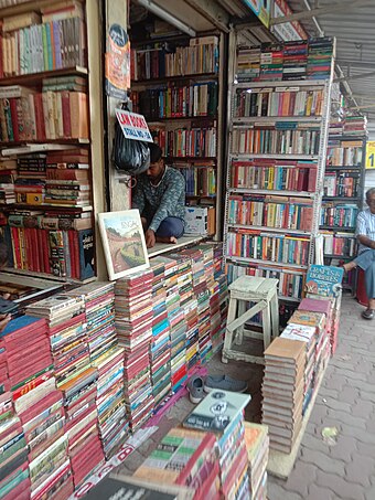 Roadside book stall and bookseller, College Street, Kolkata, India.