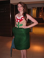 A cosplayer wearing a shirt which depicts a version of the Piranha Plant's appearance in 2D art form.