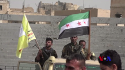 FSA fighters in the SDF in Raqqa, 6 March 2018. SDF fighters in Raqqa stadium.png