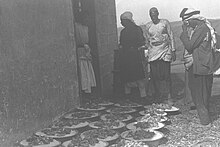 Servants waiting to serve bowls of rice and roast lamb to guests attending an Arab farmer's wedding in the Negev. mnvt Avkl SHl Avrz vbSHr mvkn lhgSHh lA SERVANTS WAITING TO SERVE BOWLS OF RICE AND ROAST LAMB TO GUESTS ATTENDING AN ARAB FARMER'S WEDDING IN THE NEGEV. mnvt Avkl SHl Avrz vbSHr mvkn lhgSHh lA.jpg