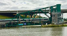 The old bascule span now in Petaluma, California. It was repainted to match the theme color for the commuter train seen here. The taller bridge in the background is US 101. SMART Train crossing the drawbridge.jpg