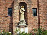 The sculpture of St Martha stands in a niche on the west front above the foundation stone.