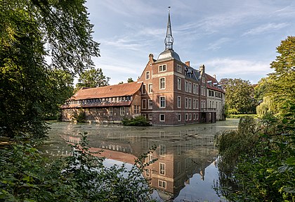 Castelo de Senden, em Senden, Renânia do Norte-Vestfália, Alemanha. Ele é um dos muitos castelos com fosso na região de Münsterland e está localizado no rio Stever, que alimenta o fosso do castelo. Além disso, o canal Dortmund-Ems fica a cerca de 250 metros de distância. Ludeke Droste (1405–1466) construiu o Castelo de Senden, que mais tarde foi ampliado várias vezes, como uma casa fortificada na forma de um castelo com fosso. Seu filho, Sander II, Droste zu Senden (1448-1502) construiu a mansão em sua forma atual, que com sua empena de três níveis é provavelmente o mais antigo monumento preservado desse tipo e um modelo para edifícios da Renascença da Vestefália. Após anos de má conservação e abandono, o castelo foi adquirido pela associação sem fins lucrativos Schloss Senden e.V. e em 2015 deu início ao trabalho de restauração do complexo arquitetônico. O Comissário do Governo Federal para Cultura e Mídia, o Governo do Distrito de Münster, a Fundação Alemã para Proteção de Monumentos e o município de Senden concederam financiamento para o reparo geral em andamento das instalações. (definição 6 714 × 4 580)