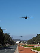 Two C-130 Hercules transport aircraft flying up Anzac Parade