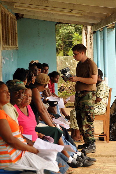 File:US Navy 081117-N-8907D-170 Hospital Corpsman Michael Hagglung talk with patients awaiting eye examinations during medical operations at the Port Kaituma Skills Training Centre.jpg