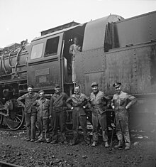 Following the Anglo-Soviet invasion of Iran, American and British railroad crews pose alongside a locomotive, ca. 1943. American and British railroad crews who are taking supplies for Russia. Somewhere in Iran.jpeg