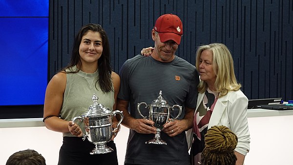 Bianca Andreescu poses with her coach, Sylvain Bruneau, and a USTA official following her press conference, after winning the 2019 US Open title at Ar