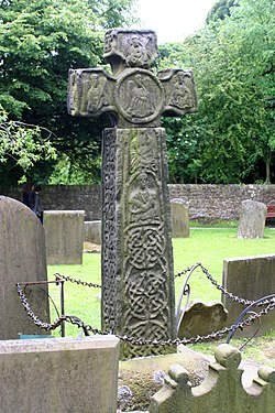 cruz do século VIII em Eyam em Derbyshire com entrelaçamento; veja aqui o rosto com pergaminhos de videira