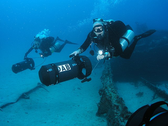Two divers scootering with heavy duty DPVs
