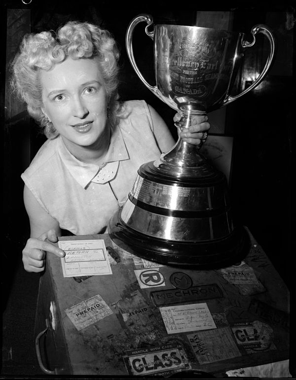 Woman poses with Grey Cup in 1955.