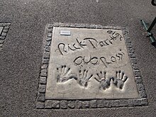 Handprints in the Munich Walk of Stars in Germany (pictured in 2015) Handprints of Status Quo in Olympiapark, Munich.jpg