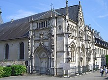 Foto della facciata occidentale (cappella Belley o Estavayer) della chiesa abbaziale, completata nel 1837. A sinistra, la vecchia porta realizzata da Claude d'Estavayer.