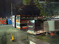 The Isle of Wight Festival 2010 bus station, off Fairlee Road, Newport, Isle of Wight, seen at night. Buses from various operators can be seen parked up for shuttle services to various ferry ports around the island. Also visible is Southern Vectis' 095, an old coach converted into a mobile restroom for staff at events.