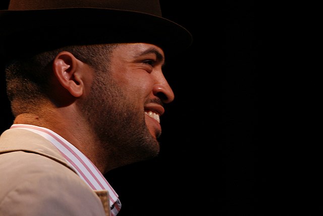 profil d'un Noir-Américain souriant avec une petite barbe et un chapeau