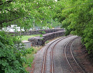 Ein Paar gebogener Eisenbahnschienen von einer Brücke aus gesehen