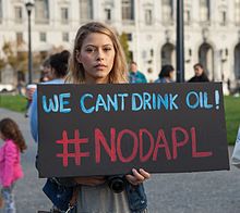 A person protesting the Dakota Access Pipeline holds a sign reading "We can't drink oil! #NoDAPL" Stand with Standing Rock SF Nov 2016 08.jpg