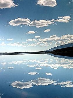 Summit Gölü'nün mavi sularında hafif bulutlu mavi gökyüzü manzarası
