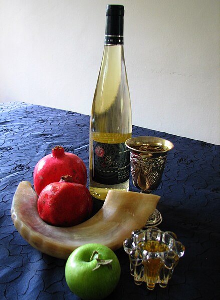 Rosh Hashana symbols: shofar, apples and honey, pomegranates, kiddush wine