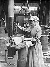 Photographie en noir et blanc d’une femme travaillant le bois