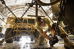 U.S. Air Force Staff Sgt. Ryan Vanterpool, an aerial porter with the 455th Expeditionary Aerial Port Squadron, chains down a mine-resistant, ambush-protected vehicle aboard an Air Force C-17 Globemaster III 131002-F-YL744-098.jpg