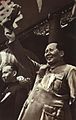 Mao Zedong dan Liu Shaoqi memberi isyarat kepada orang ramai pada Hari Kebangsaan pada tahun 1950