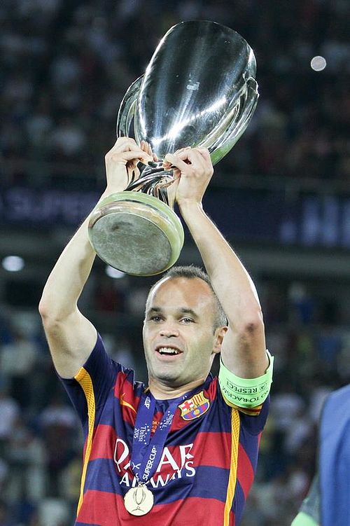 Barcelona captain Andrés Iniesta lifting the 2015 UEFA Super Cup trophy.