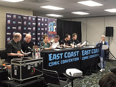 Romano, at right, directing the voice cast of Batman: The Animated Series in a table reading at the 2019 East Coast Comicon