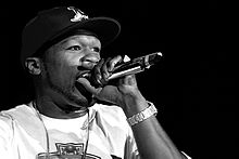 Primer plano en blanco y negro de 50 Cent cantando en el escenario