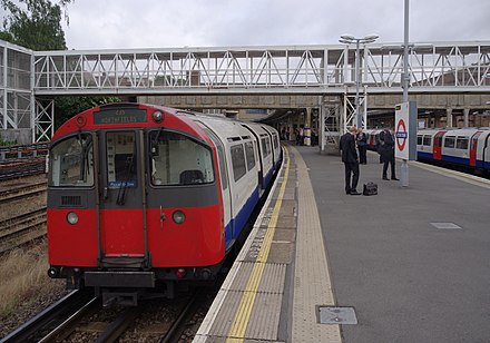A westbound Piccadilly line train stands on a westbound platform at Acton Town looking west. This platform is unique in being usable by trains of both the District and Piccadilly lines.