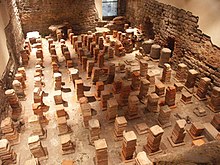 Caldarium from the Roman Baths at Bath, in Britain. The floor has been removed to reveal the empty spaces through which the hot air would flow. Caldarium.JPG